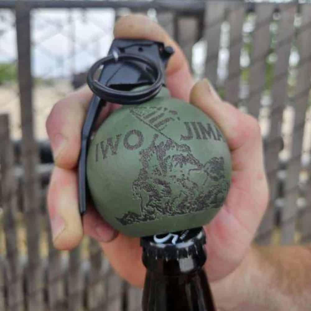 freedom frag bottle opener in OD green with IWO Jima logo on the front opening a bottle